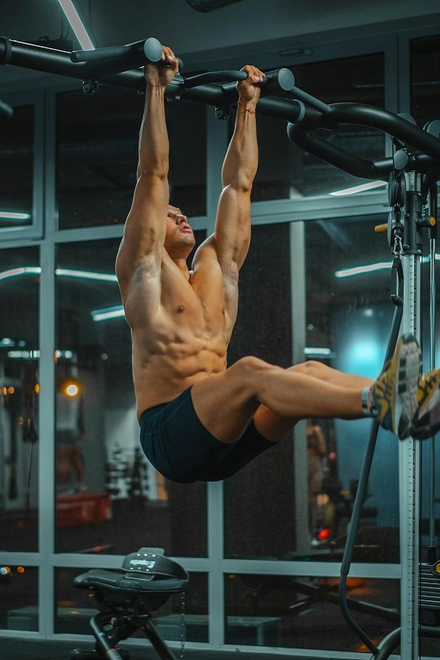 Man on pull-up bar training his core